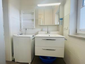 Un baño blanco con lavabo y espejo. en Ferienwohnung Hoherting, en Prien am Chiemsee 8 fotos más