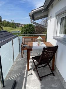 a wooden table and a chair on a balcony at Ferienwohnung Hoherting in Prien am Chiemsee