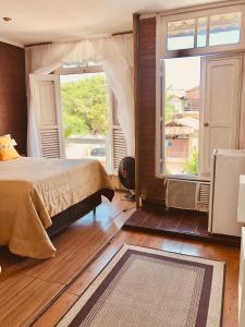 una camera da letto con un letto e una grande finestra di Casa de praia aconchego a Rio de Janeiro