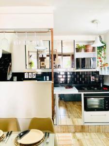 una cucina con mobili bianchi e un tavolo di Casa de praia aconchego a Rio de Janeiro