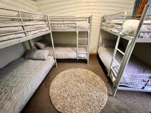 a room with two bunk beds and a rug at Private Heated Bedrooms at The Bunkhouse in Snowdonia Perfect for Bikers and Walkers in Dolgellau