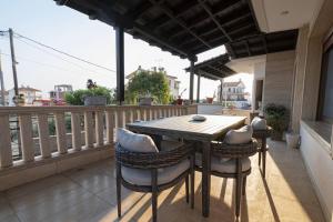 ein Holztisch und Stühle auf einem Balkon in der Unterkunft Villa Anastazia in Paralia Dionisiou