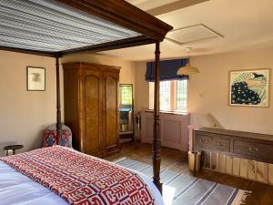 a bedroom with a canopy bed and a desk at The Governor's House at The Tanyard, Lacock in Lacock