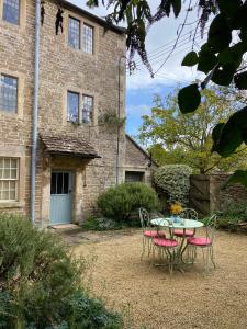a table and chairs in front of a building at The Governor's House at The Tanyard, Lacock in Lacock