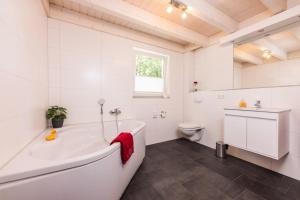 a white bathroom with a tub and a toilet at Lee - Nordhorn in Nordhorn