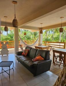 a living room with a black couch and a table at Apto Gostoso andar Cantina in São Miguel do Gostoso