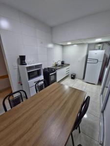 a kitchen with a wooden table and a kitchen with appliances at Apartamento próximo Cambui in Campinas +10 photos