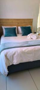 a large bed with blue and white sheets and pillows at LANGA 'S COZY GUESTHOUSE in Pretoria