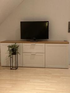 a flat screen tv sitting on top of a white cabinet at Gästewohnung 25 in Wildeshausen