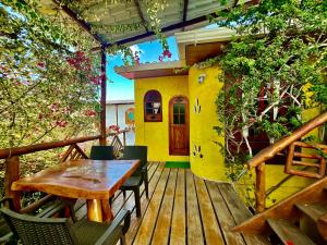 a wooden deck with a table and chairs on a house at Casa del Lago Lodging House in Puerto Ayora
