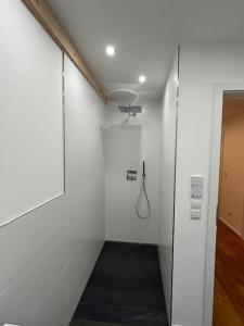 a hallway with a shower in a white wall at BERGSEERUHE - FeWo Iseler in Nesselwang