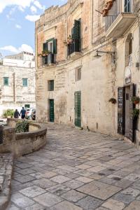 an alley in an old stone building with green doors at Fiorentini 22 - Suite Luxury con SPA in Matera