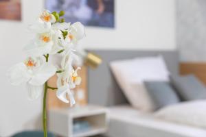 a vase filled with white flowers on a table at NINO-Boardinghouse 6 in Nordhorn
