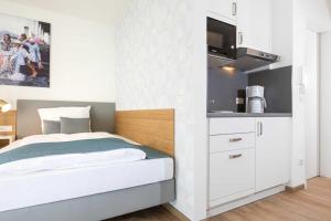 a small bedroom with a bed and a kitchen at NINO-Boardinghouse 11 in Nordhorn