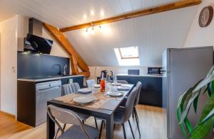 a dining room with a table and a kitchen at Appartement balnéo-détente in Sainte-Hélène-du-Lac