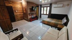 a room with a bedroom with a bed and a couch at Kurupy in Puerto Iguazú