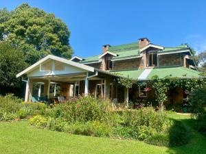 una casa con tetto verde e un cortile di Glen Eden Lodge a Lidgetton