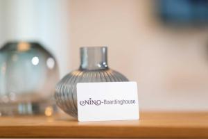 a vase sitting on a wooden shelf with a white sign at NINO-Boardinghouse 23 in Nordhorn