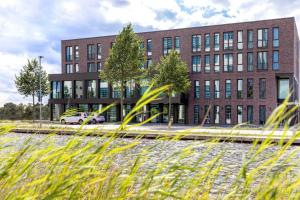 a brick building with a car parked in front of it at NINO-Boardinghouse 18 in Nordhorn