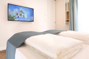 a bedroom with two beds and a tv on the wall at NINO-Boardinghouse 18 in Nordhorn