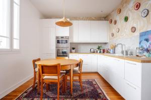 a kitchen with a wooden table and chairs at Chambre chez l'habitant - Arty & Élégante - SDB privée in Nantes