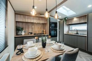 a dining room with a table and chairs in a kitchen at Corrie Fee Lodge in Boat of Garten