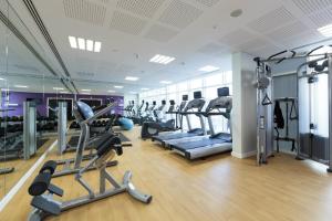 a gym with several treadmills and elliptical machines at Premier Inn Doha Education City in Doha