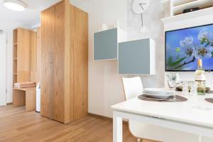 a kitchen with a white table and a tv on a wall at NINO-Boardinghouse 11 in Nordhorn