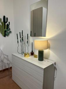 a table with a lamp and a mirror on it at Casa della Pesa in Faenza