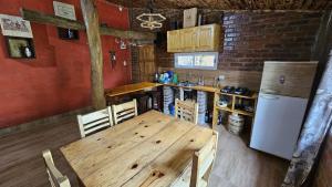 a kitchen with a wooden table and a refrigerator at Kurupy in Puerto Iguazú +5 photos