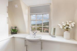 baño blanco con lavabo y ventana en Lovely Georgian Loft in The Very Centre of Bath, en Bath 21 fotos más