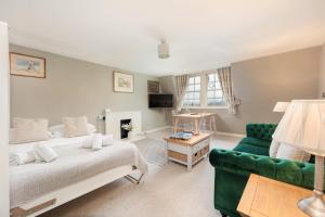 Un dormitorio con una cama y un sofá verde. en Lovely Georgian Loft in The Very Centre of Bath, en Bath