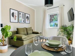 施塔特贝根Modern und stilvoll eingerichtetes Tiny House的客厅配有沙发和带酒杯的桌子