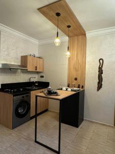 a kitchen with a table and a stove and a sink at Atlas appartement in Fez