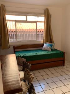 een slaapkamer met een raam met een bed en stoelen bij Sol-datelli Apês Floripa in Florianópolis
