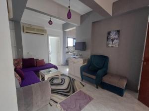 - un salon avec un canapé violet et une chaise dans l'établissement Holiday Apartment in Sunshine - Naama Bay, à Charm el-Cheikh