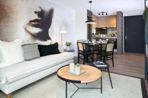 a living room with a white couch and a table at Departamento amoblado La Florida in Santiago