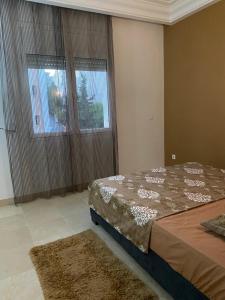 a bedroom with a bed and two large windows at Appartement S2 prés de clinique ennasser 2 in Burj at Turkī