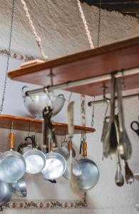a bunch of pots and pans hanging from a shelf at Morada da Praia - Porto de Pedras à Beira-Mar in Pôrto de Pedras