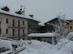 einen schneebedeckten Innenhof mit Gebäuden im Hintergrund in der Unterkunft Casa Elisa in Doues