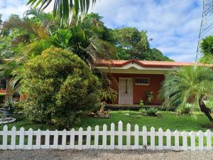 a house with a white fence in front of it at La Esmeralda Villa in Orotina