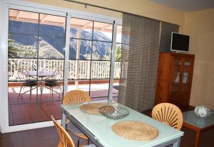 a dining room with a table and chairs and a balcony at Los Paredones 2 in Valle Gran Rey