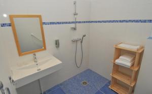 La salle de bains est pourvue d'un lavabo et d'un miroir. dans l'établissement Auberge des VoyaJoueurs, à Monteneuf