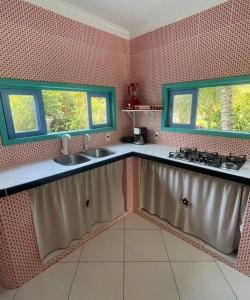 a kitchen with a sink and two windows in it at Recanto dos Valles in Búzios