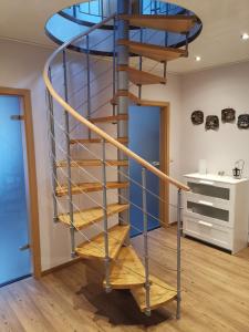 a spiral staircase in a room with wooden floors at Ferienwohnung am Dörenberg in Georgsmarienhütte +6 photos