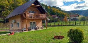 a small house with a gambrel roof on a yard at Vikendica Mandic in Gornji Volari