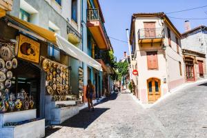 a woman walking down a street next to buildings at Agiasos House in Agiásos