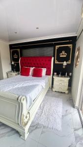 ein Schlafzimmer mit einem großen weißen Bett mit roten Kissen in der Unterkunft House of Royalty in Walmer