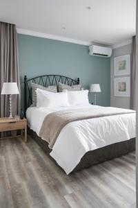 约翰内斯堡Studio Stay on Sixty6的卧室里有一张大床，床单和枕头都是白色的