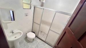 a bathroom with a shower and a toilet and a sink at Biônica Pousada in Cayru